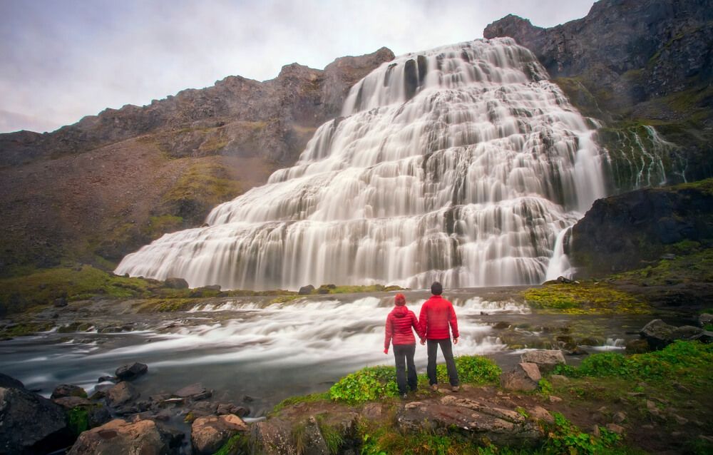 People standing in front of Dynjandi waterfall in Iceland Westfjords.