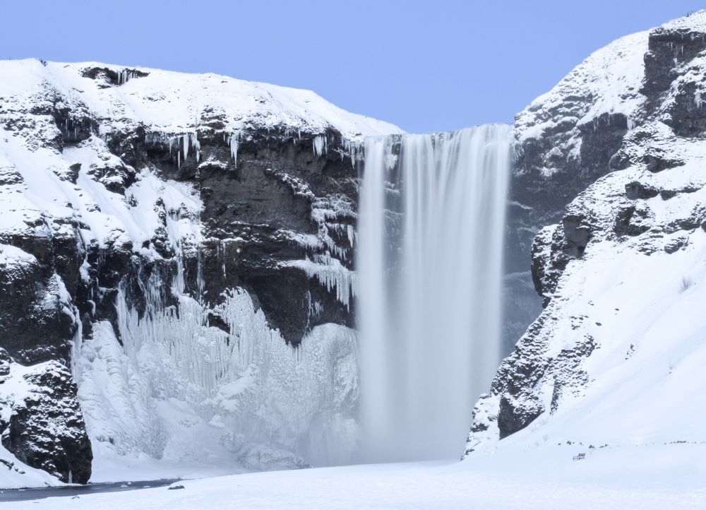 Skógarfoss waterfall, frozen and in winter uniform.