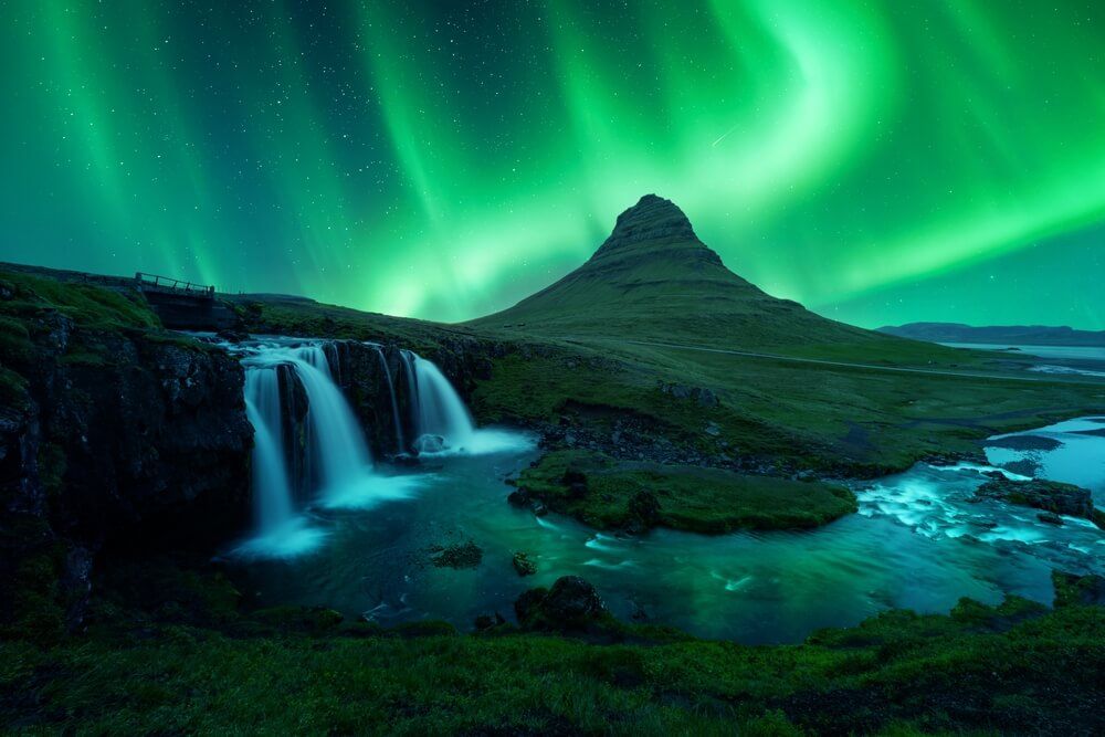 Kirkjufell mountain and Kirkjufell waterfall under the northern lights at Snæfellsnes peninsula.