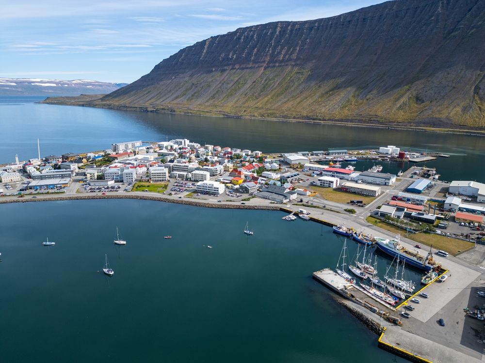 Aerial view of Ísafjörður town and harbor in the Westfjords, Iceland, surrounded by fjords and mountains