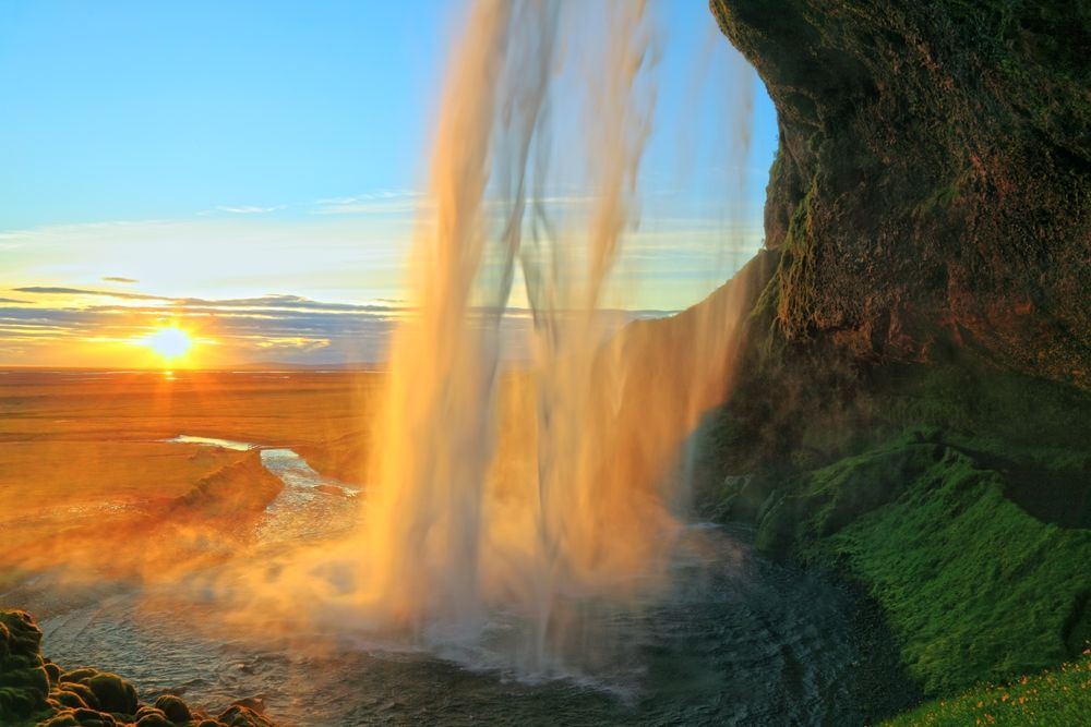 Midnight sun view behind Seljalandsfoss waterfall.