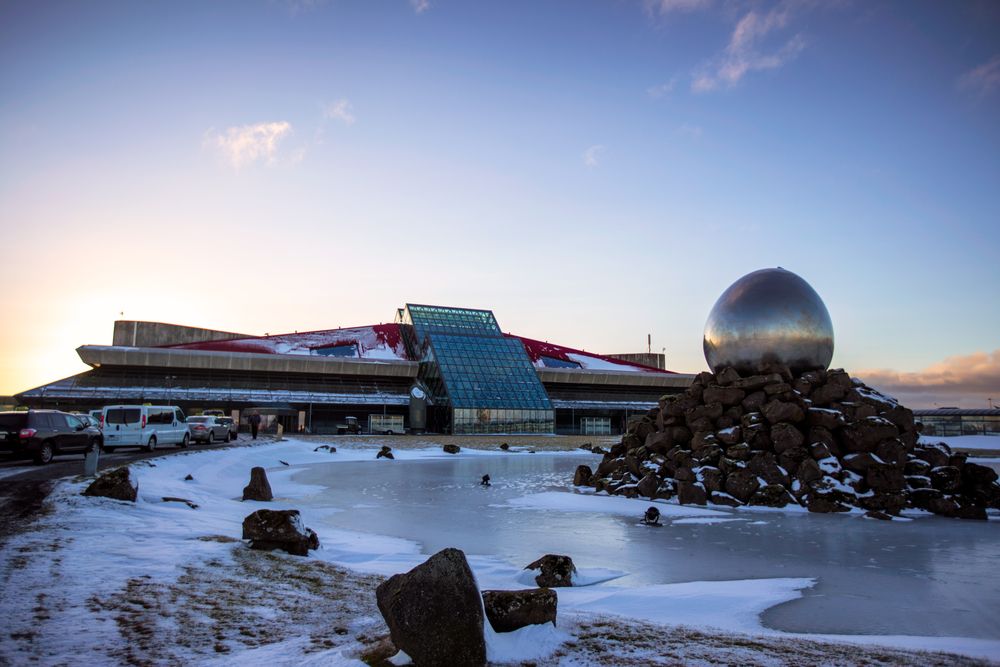 Winter scene at Keflavik Airport with globe sculpture and main terminal entrance